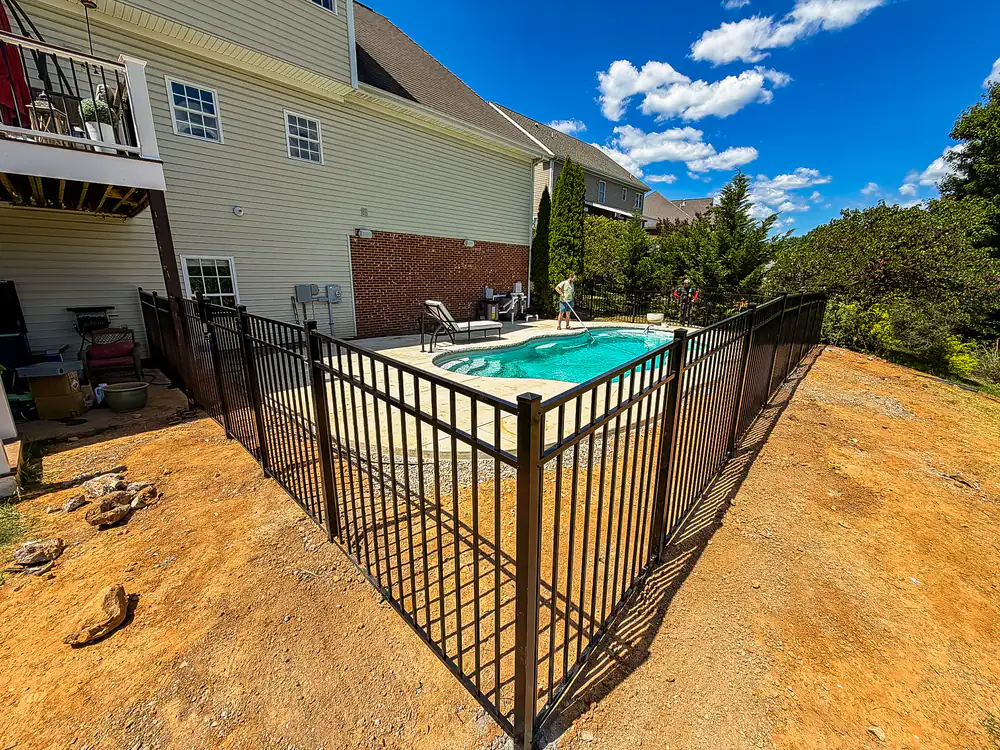 Black aluminum pool fence with tight picket spacing around a backyard pool in Roanoke
