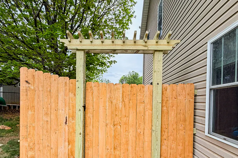 Wood privacy fence gate topped with a custom cedar arbor in Roanoke