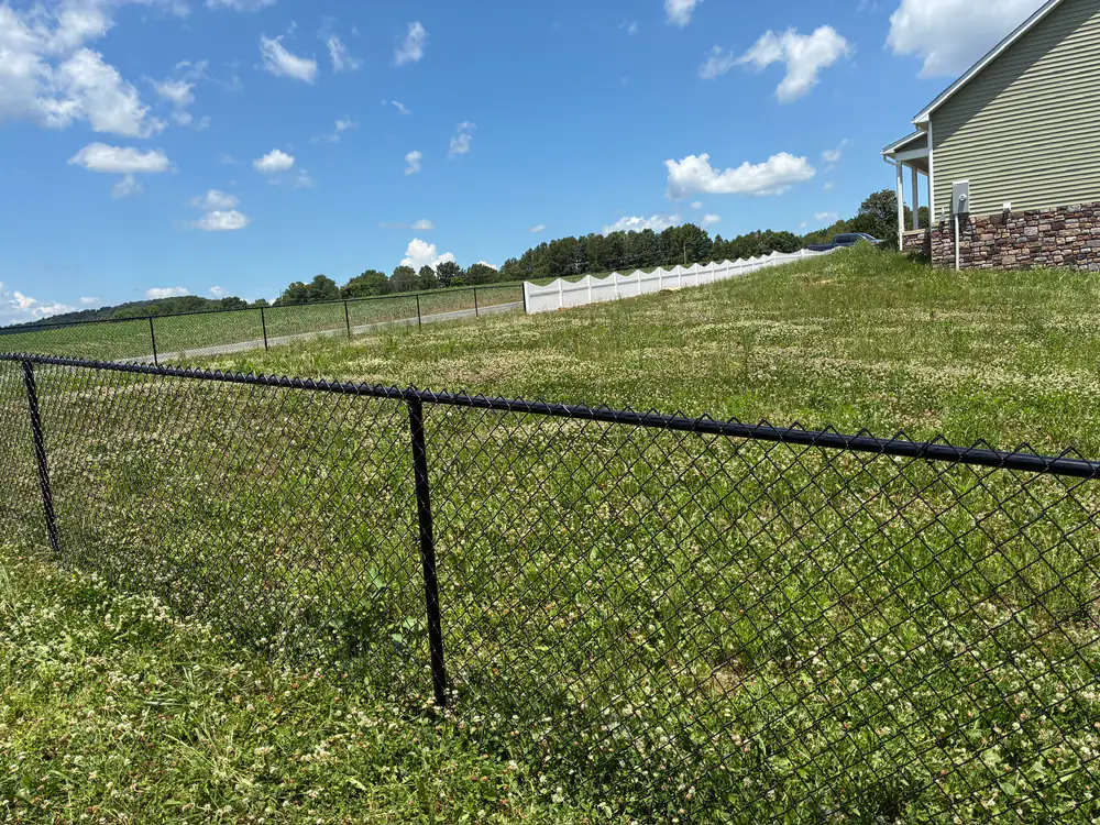 Black chain link fence along an open field near Roanoke