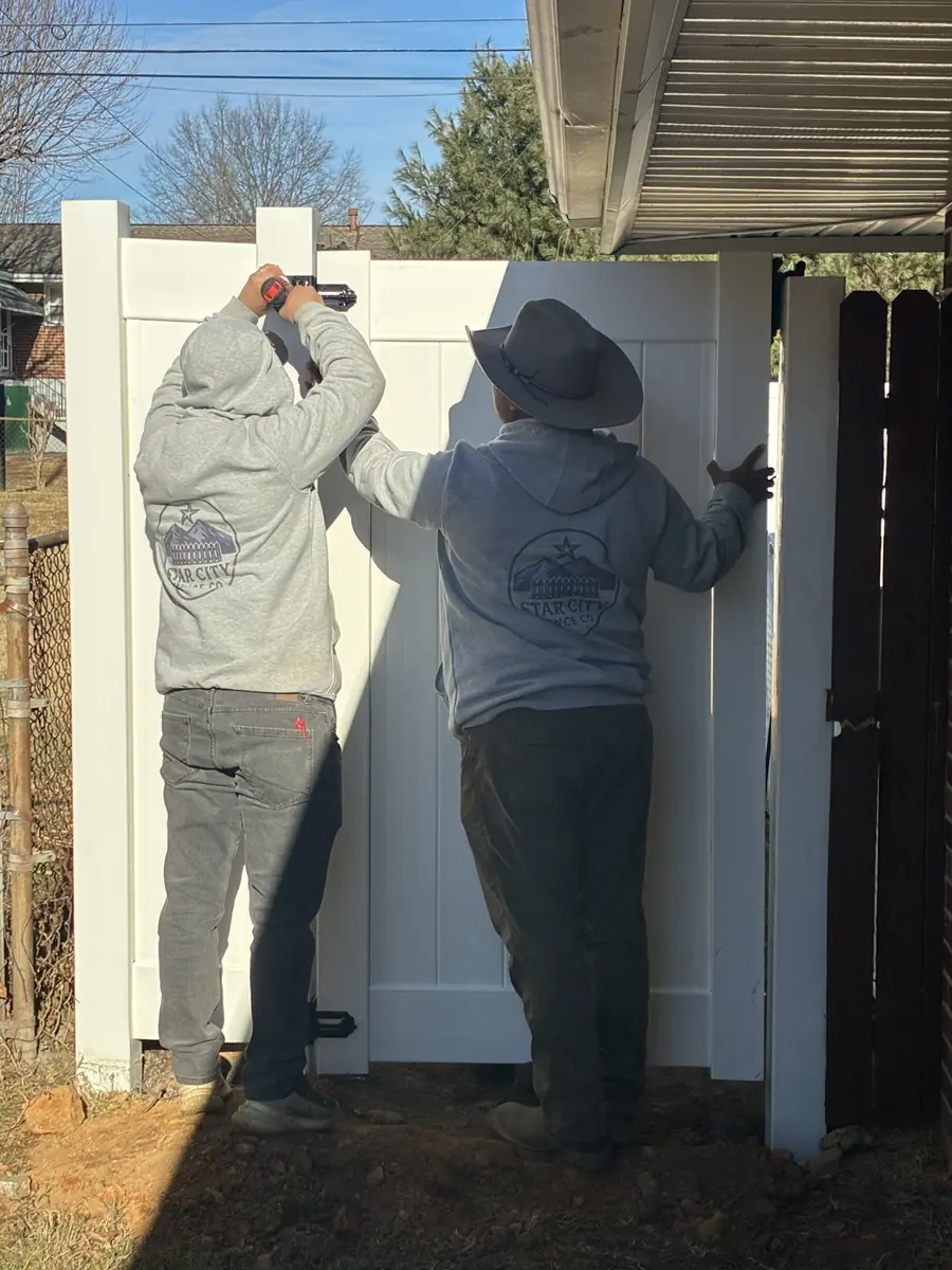 Star City Fence Co crew installing a vinyl gate wearing branded hoodies