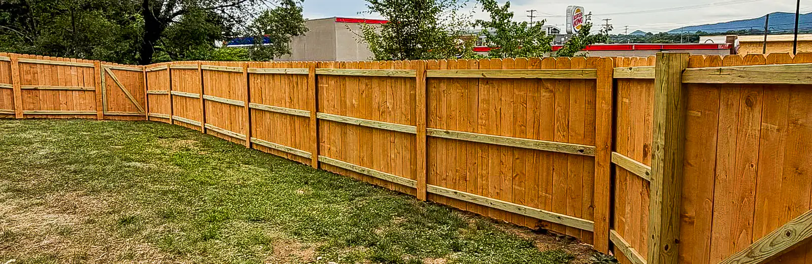 Long run of new wood privacy fence under a dramatic sky in Roanoke
