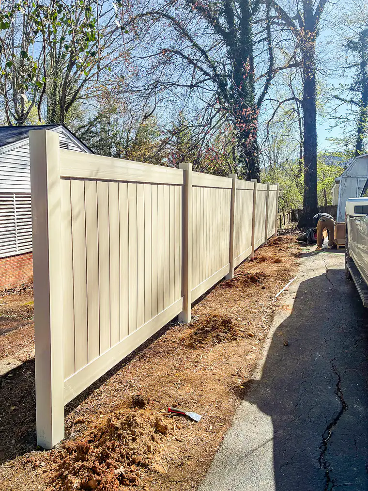 Almond-colored vinyl privacy fence along a narrow side yard in Roanoke