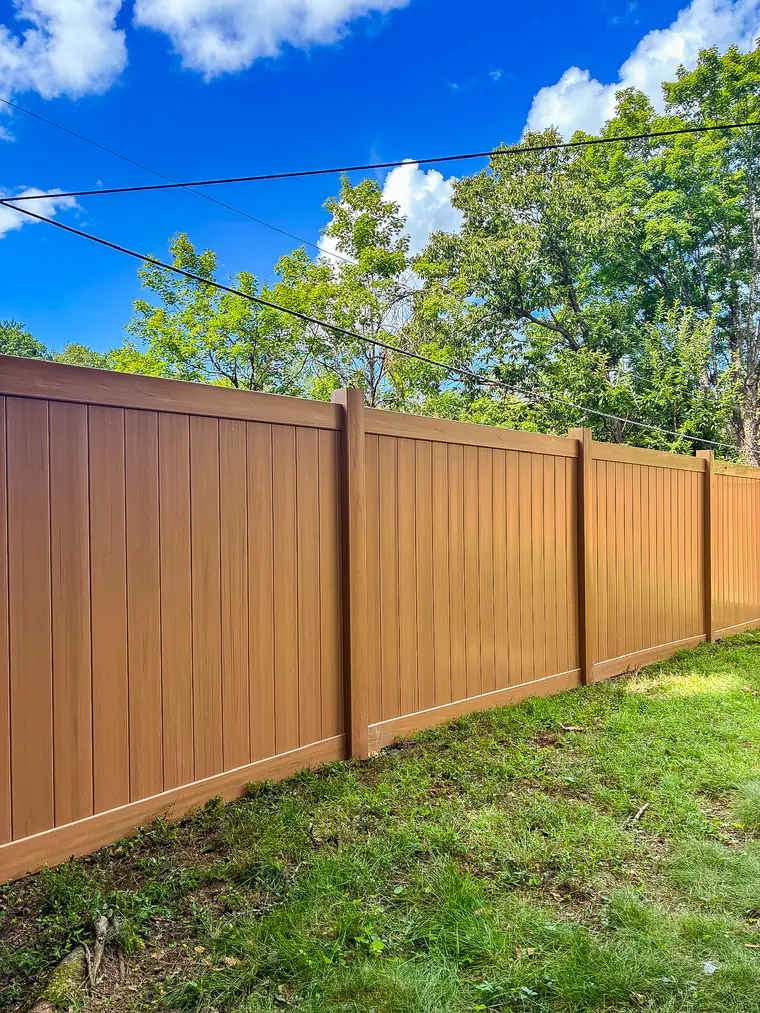 Cedar wood-grain vinyl privacy fence enclosing a Roanoke backyard