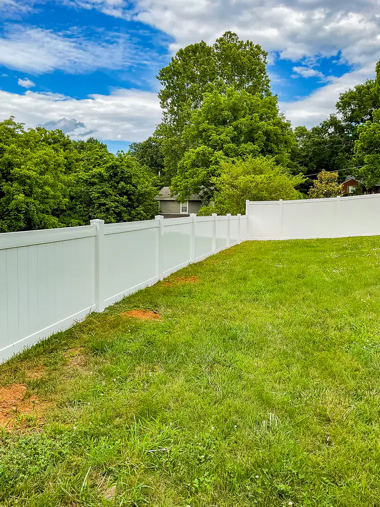 White vinyl privacy fence along a shaded backyard in Roanoke