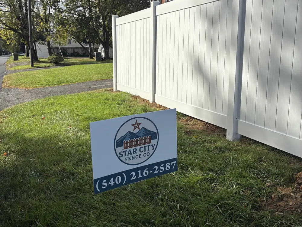 White vinyl privacy fence with Star City Fence Co yard sign