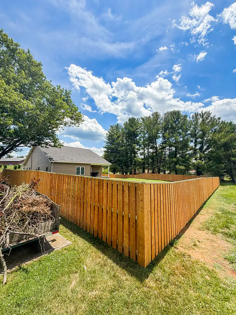 Long run of new wood privacy fence around a Roanoke backyard under a blue sky