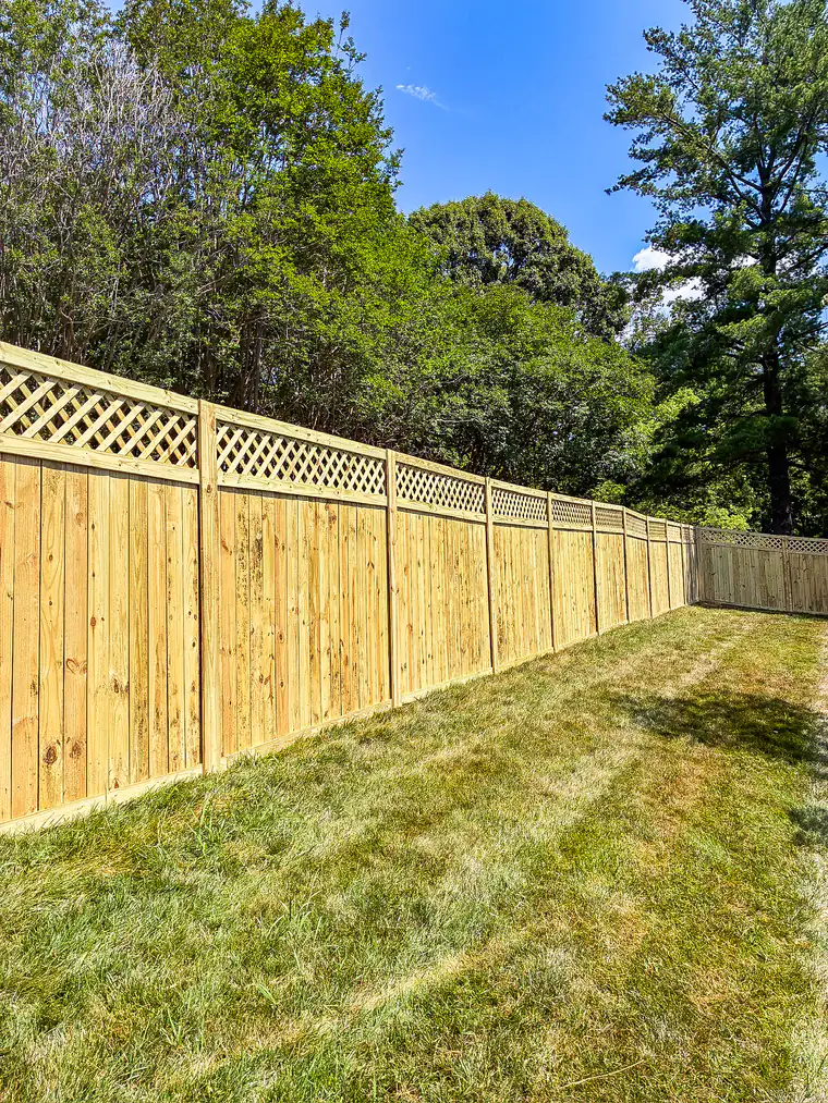 Wood privacy fence topped with decorative lattice panels in a Roanoke backyard