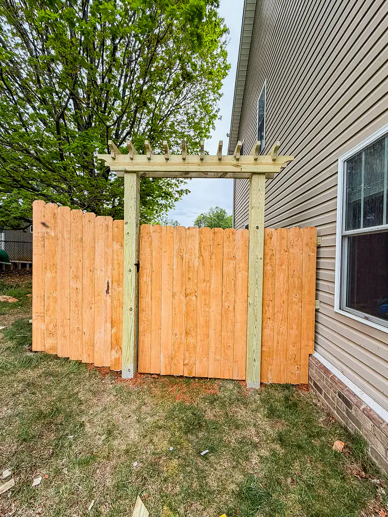 Wood privacy gate topped with a custom cedar arbor in Roanoke