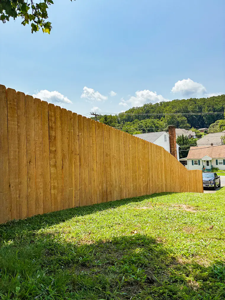 Tall wood privacy fence stepping down a hillside lot in Roanoke